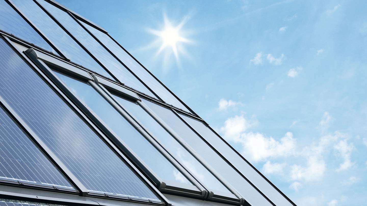 DachKomplett Lösungen und Leistungen rund um das Thema Energetische Modernisierung. Dachflächenfenster umgeben von Photovoltaik-Modulen von Roto. Bildquelle: Roto