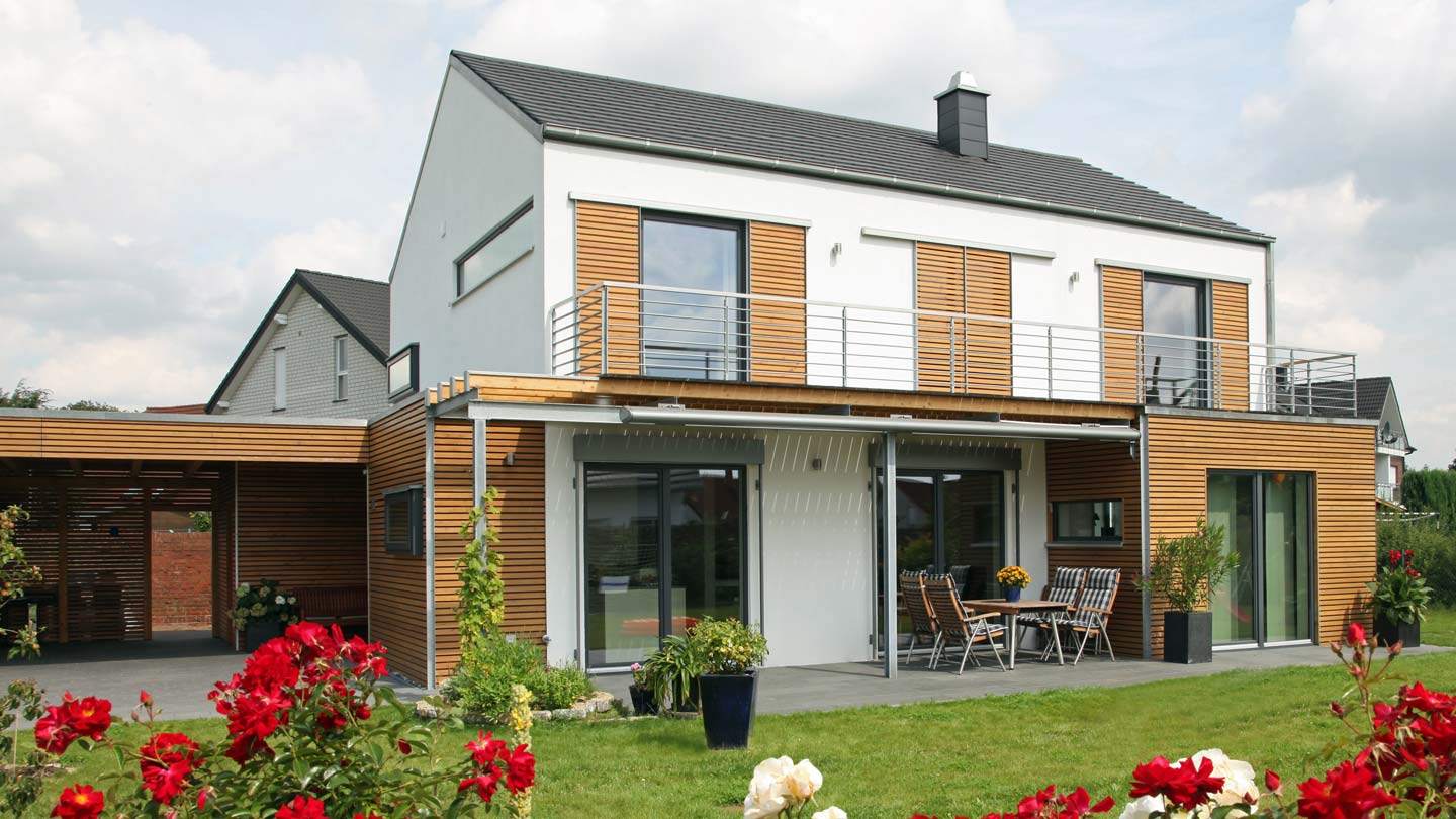 DachKomplett Lösungen und Leistungen rund um das Thema Fassade / Fassadenmodernisierung. Außenansicht eines Einfamilienhauses mit moderner Holzfassade.